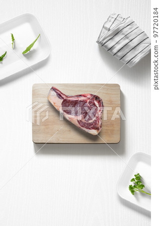 Beef steak on a cutting board on a kitchen with some herbs 97720184