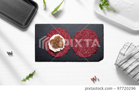 Stuffed hamburguer on a flat lay of a kitchen with various items 97720296