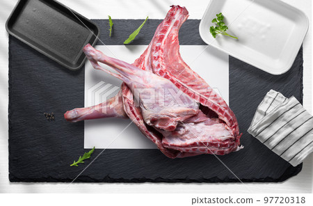 Half a goat on a flat lay of a butcher shop with various items 97720318