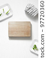 Flat lay of a kitchen with a cutting board and herbs 97720360