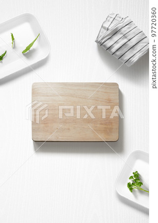 Flat lay of a kitchen with a cutting board and herbs Flat lay of a kitchen with a cutting board and herbs 97720360