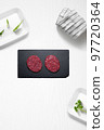 Beef burguers on a kitchen with some herbs 97720364