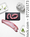 Criollo chorizo and pork ribs on a kitchen with some herbs 97720373