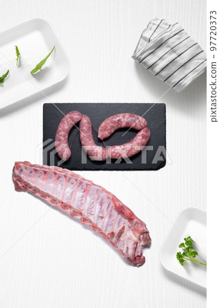Criollo chorizo and pork ribs on a kitchen with some herbs 97720373