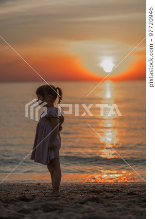 girl playing on the beach at sunset. Family holiday. High quality photo. 97720946