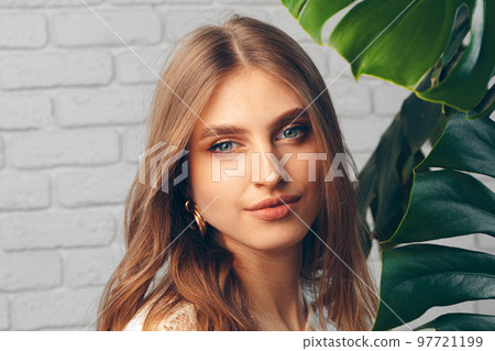 Portrait of a beautiful woman with monstera leaves Portrait of a beautiful woman with monstera leaves 97721199