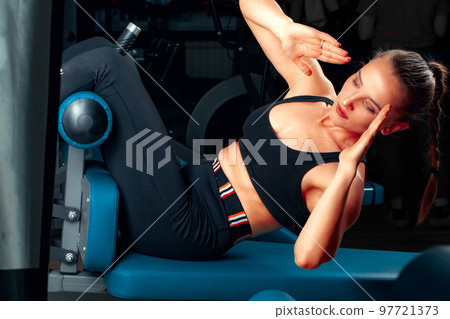 Slim girl working out in training apparatus Slim girl working out in training apparatus 97721373