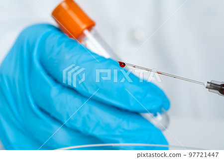 Doctor in blue gloves keep in hands test tube with a blood and syringe Doctor in blue gloves keep in hands test tube with a blood and syringe 97721447