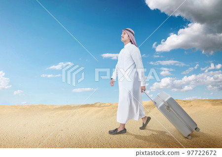 Arab man wearing keffiyeh and agal walking with a suitcase for traveling Arab man wearing keffiyeh and agal walking with a suitcase for traveling 97722672