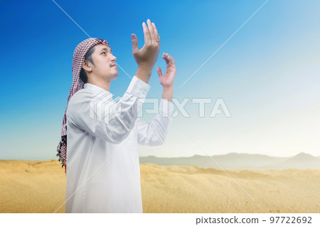 Muslim man with keffiyeh and agal raised hands and praying Muslim man with keffiyeh and agal raised hands and praying 97722692