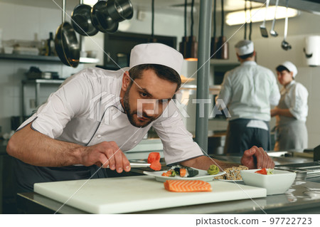 Sushi master prepares sushi for serving in modern commercial kitchen Sushi master prepares sushi for serving in modern commercial kitchen 97722723