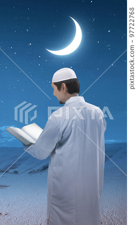 Muslim man standing and reading the Quran 97722768