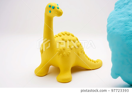 Cute yellow plasticine dragon with green pimples isolated on white background Cute yellow plasticine dragon with green pimples isolated on white background 97723393