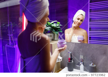 A girl takes care of her face and skin after a shower. A girl takes care of her face and skin after a shower. 97723962