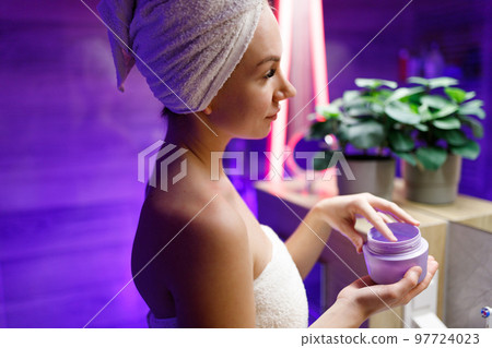 A girl takes care of her face and skin after a shower. 97724023