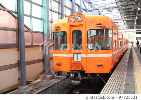 Ichibata train cars stopping at the platform of Dentetsu Izumoshi Station 97725521