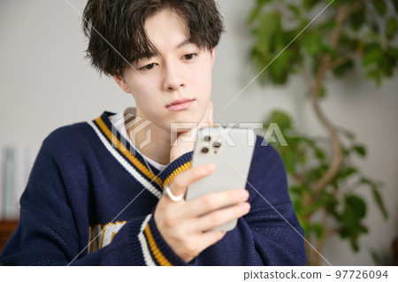 看他的智能手機的一個年輕人 看他的智能手機的一個年輕人 97726094