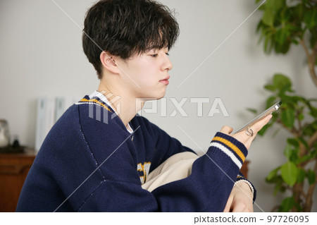 看他的智能手機的一個年輕人 97726095