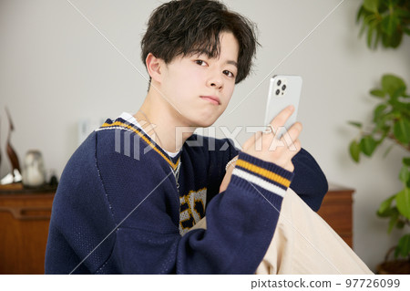 看他的智能手機的一個年輕人 97726099