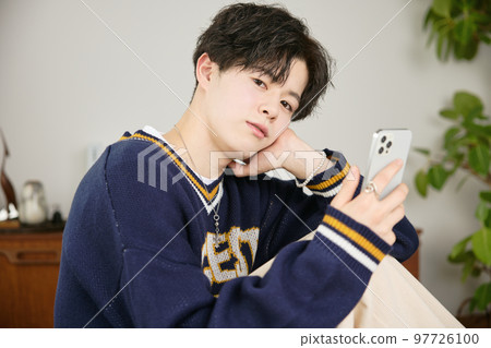 看他的智能手機的一個年輕人 看他的智能手機的一個年輕人 97726100