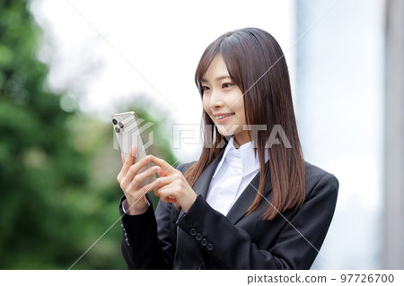 穿著西裝的女商人操作智能手機 97726700