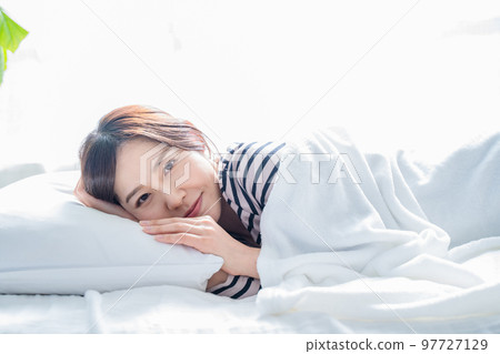 微笑的女人在床上睡個好覺醒來 97727129