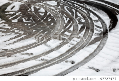 Wheel tracks on the road covered with snow 97727471