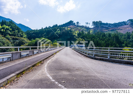 Hikawa Dam "View of Hikawa Dam, a tourist attraction with a beautiful mountain range in the background" 97727811
