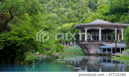New Athos, Abkhazia, Georgia - June 2022. View of the building of the Psyrtsha railway station in New Athos from the side of the lake. 97728166