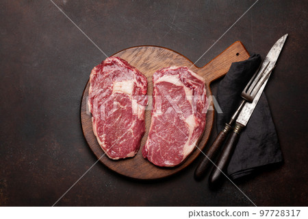 Two raw ribeye beef steaks 97728317