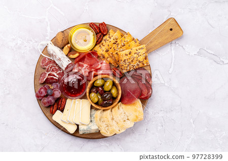Antipasto board with prosciutto, salami, crackers, cheese Antipasto board with prosciutto, salami, crackers, cheese 97728399
