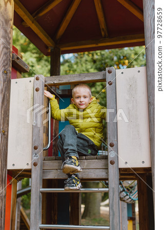 Boy At The Climbing Wall Without A Helmet, Danger At The Climbing Wall. Little Boy Climbing A Rock Wall Indoor Boy At The Climbing Wall Without A Helmet, Danger At The Climbing Wall. Little Boy Climbing A Rock Wall Indoor 97728659