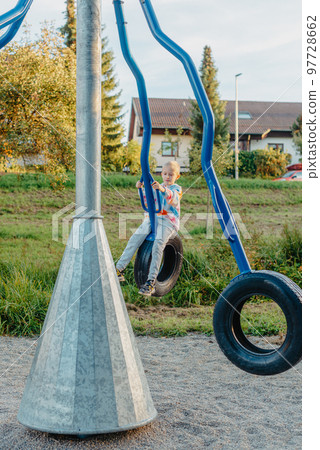Funny cute happy baby playing on the playground. The emotion of happiness, fun, joy. Smile of a child. boy playing on the playground 97728662