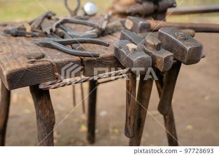 Blacksmith tools and instruments at outdoor forge, workshop - close up 97728693