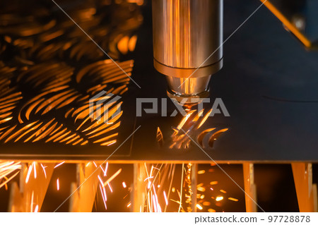 Laser cutting machine working with sheet metal with sparks in dark: close up 97728878