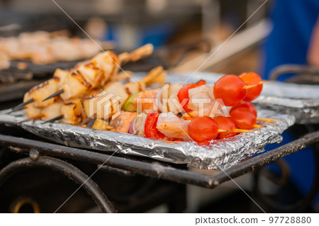 Cooked scallop and shrimp, prawn skewers, cherry tomato on foil - street food Cooked scallop and shrimp, prawn skewers, cherry tomato on foil - street food 97728880