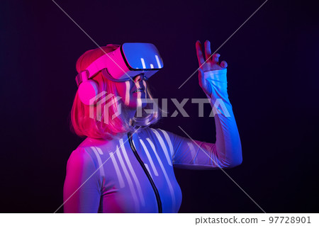Woman in virtual reality goggle in neon colors. 97728901