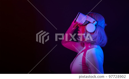 Woman in virtual reality goggle in neon colors. Woman in virtual reality goggle in neon colors. 97728902