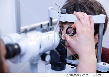 Mid aged woman having an optometric investigation Mid aged woman having an optometric investigation 97729109