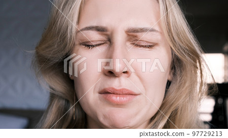 Portrait of crying grieving woman of 30 years. Grimace of sadness with tears in her eyes and crooked chin of blonde woman looking at camera. Emotional swing, unstable psyche, mental problems Portrait of crying grieving woman of 30 years. Grimace of sadness with tears in her eyes and crooked chin of blonde woman looking at camera. Emotional swing, unstable psyche, mental problems 97729213