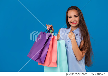 Beautiful young woman with colorful shopping bags on the wonderful blue background 97730574