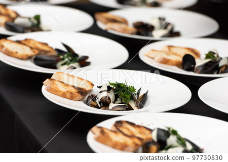 chief serving mussels in white wine sauce and white bread toasts chief serving mussels in white wine sauce and white bread toasts 97730830