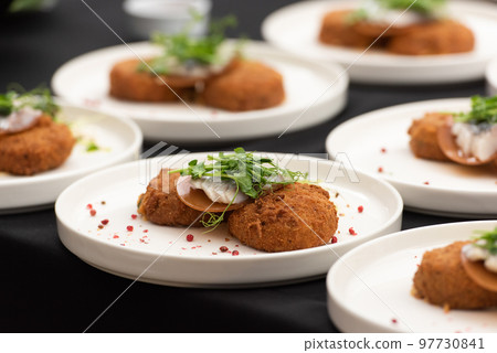 chief serving herring with potato Kroket croquette Dutchs favourite snack deep-fried ragout filled snack coated with breadcrumbs 97730841