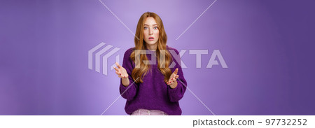 What wrong, I worried. Portrait of nervous and empathical young redhead woman feeling anxious raising hands questioned and looking at camera wondered expressing concern for friend over purple wall What wrong, I worried. Portrait of nervous and empathical young redhead woman feeling anxious raising hands questioned and looking at camera wondered expressing concern for friend over purple wall 97732252