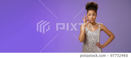 Girl make promise not tell anyone zipping mouth hold hand near pursed lips keep secret safe standing amused excited learn shocking rumor standing blue background gossiping in silver dress 97732468