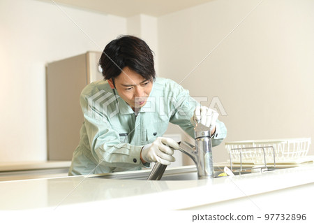 一名工人正在檢查延伸到廚房的沖洗水龍頭 97732896