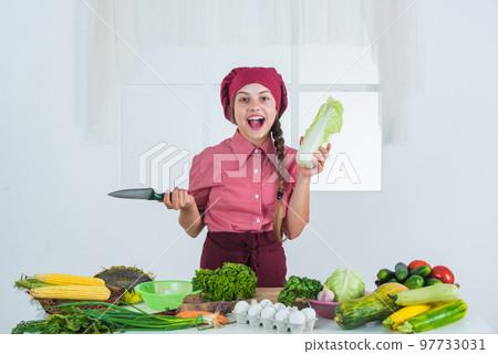 cheerful child girl cooking vitamin salad from vegetables, diet 97733031