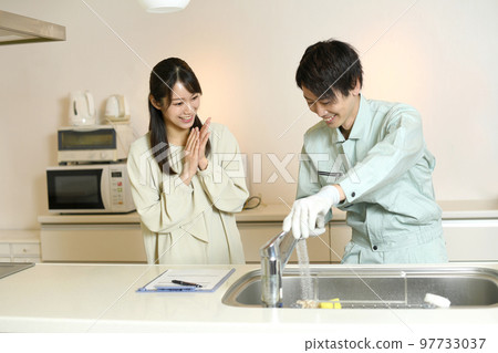 Male worker and female customer having a conversation in the kitchen 97733037