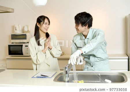 Male worker and female customer having a conversation in the kitchen Male worker and female customer having a conversation in the kitchen 97733038