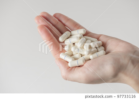 Antibiotics. The concept of antibiotic therapy, drug treatment. A woman is holding a handful of antibiotics. The use of a large number of drugs. Tablets labeled antibiotic. copy space. 97733116